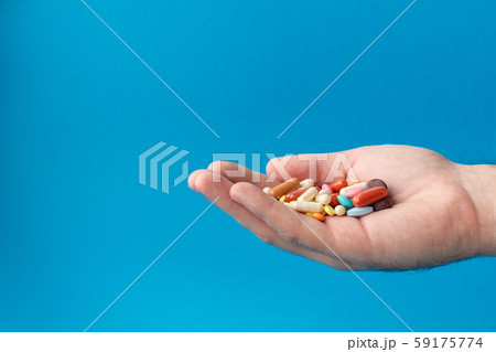 A handful of colored pills on the palm. Medical 59175774