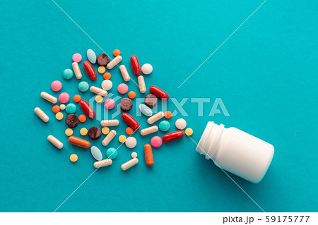 A handful of colored pills spilled out of the can 59175777