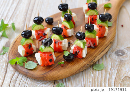 Feta cheese skewers with grilled and pickled red peppers, snack cucumbers and black olives 59175951