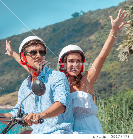 Happy couple on a scooter Happy couple on a scooter 59177473