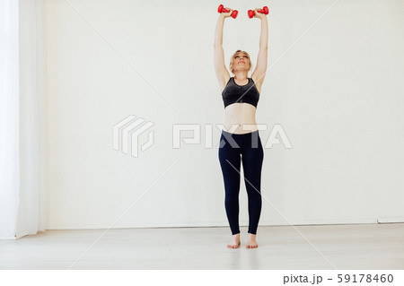 Beautiful blonde woman sports with fitness dumbbells Beautiful blonde woman sports with fitness dumbbells 59178460