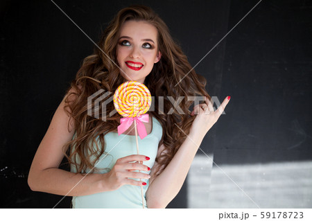 Beautiful woman with red lips eats candy big sweet lollipop Beautiful woman with red lips eats candy big sweet lollipop 59178723