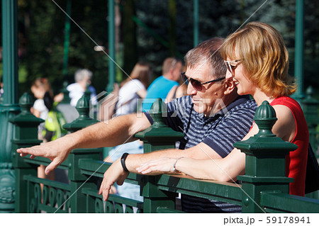 Middle-aged couple smiling and hugging on a walk Middle-aged couple smiling and hugging on a walk 59178941