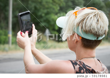 Adult blonde woman makes selfie on a smartphone on 59178981