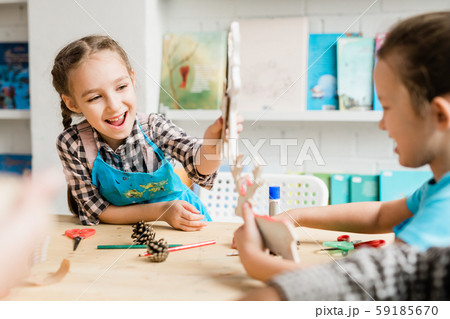 Naughty schoolgirls having fun at lesson and playing with self-made toys 59185670