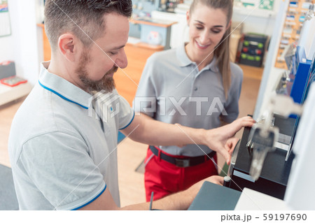 Seller in his shop with customer buying a safe 59197690