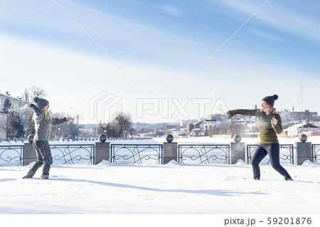 two women play snowballs 59201876