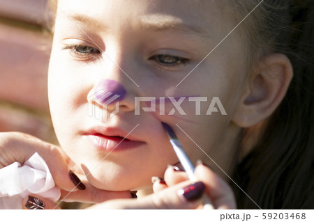 Brother paints on sister's face 59203468