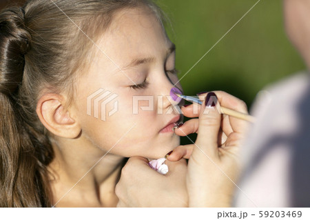 Brother paints on sister's face 59203469