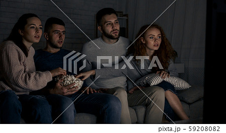 Young friends watching interesting film at home 59208082
