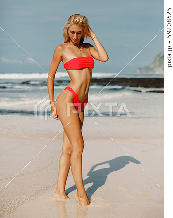 Young sexy woman with perfect body in bikini posing at tropical beach. Young sexy woman with perfect body in bikini posing at tropical beach. 59208525