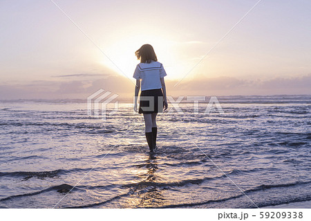 女子高生 海 後ろ姿 輝きの写真素材