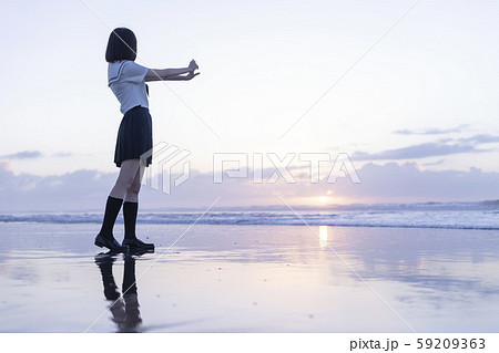 女子高生 海 後ろ姿 輝きの写真素材