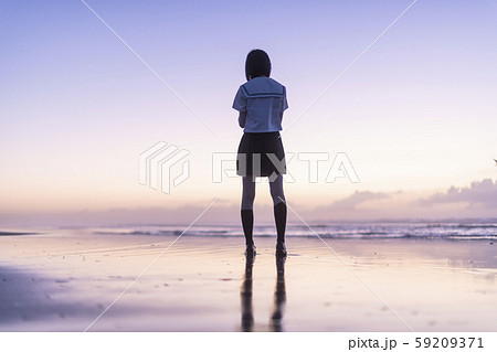 女子高生 海 後ろ姿 輝きの写真素材
