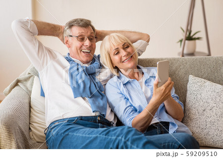 Happy mature couple using cellphone, surfing internet online Happy mature couple using cellphone, surfing internet online 59209510