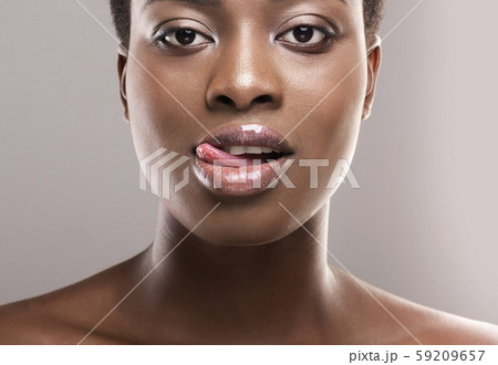 Closeup portrait of beautiful african girl licking her lips seductively Closeup portrait of beautiful african girl licking her lips seductively 59209657