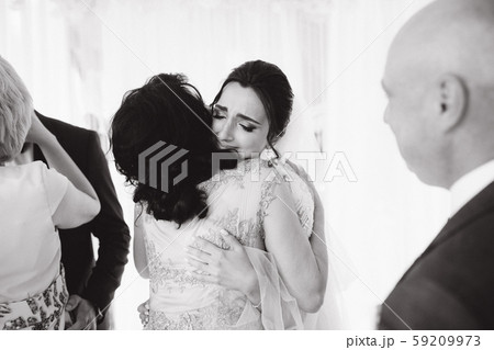 Bride hug mom after wedding ceremony and cries with joy Bride hug mom after wedding ceremony and cries with joy 59209973