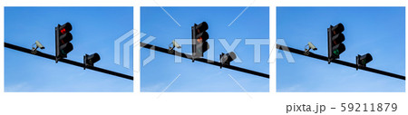 Set of red, yellow and green traffic lights and outdoor surveillance camera above a roadway Set of red, yellow and green traffic lights and outdoor surveillance camera above a roadway 59211879