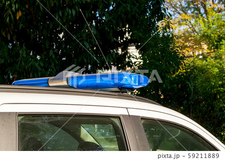 Blue warning lightbar on a police or emergency car. Roof mounted lightbar on a white vehicle.  59211889