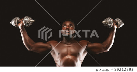 Concentrated black bodybuilder working out, pushing barbells up Concentrated black bodybuilder working out, pushing barbells up 59212293
