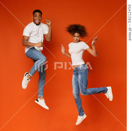 Cheerful african guy and girl jumping in air Cheerful african guy and girl jumping in air 59212450