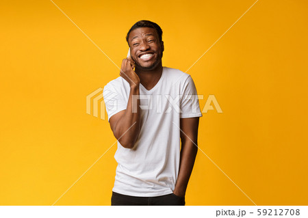 African American Man Laughing Looking At Camera Over Yellow Background 59212708