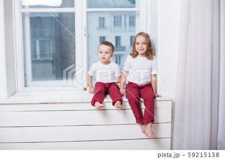 boy with girl brother and sister sitting together in a room 59215138
