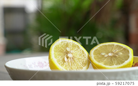 Lemon cut into half on a whilte plate 59217075