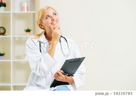 Young female doctor working in hospital office. 59220785