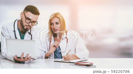 Doctors working with laptop computer in hospital. 59220786