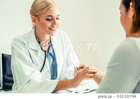Woman Doctor and Female Patient in Hospital Office Woman Doctor and Female Patient in Hospital Office 59220794