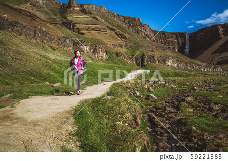 Traveler hiking at Hengifoss Waterfall, Iceland. Traveler hiking at Hengifoss Waterfall, Iceland. 59221383