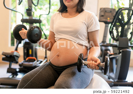 Active pregnant woman exercise in fitness center. 59221492