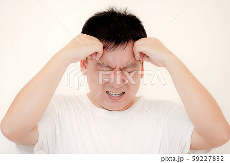 Young man is suffering from a headache,Concept healthcare and medical. Young man is suffering from a headache,Concept healthcare and medical. 59227832
