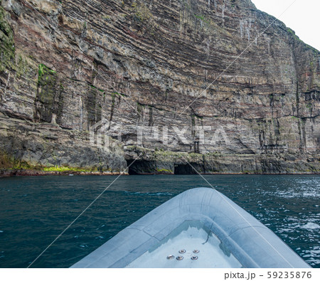 Motorboat approaching to two tunnels in the wall 59235876