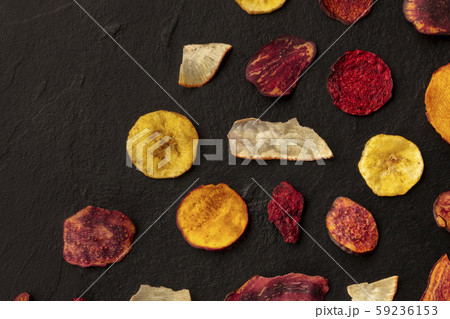 Dried fruit and vegetable crisps, overhead shot with a place for text. Healthy vegan snack, an Dried fruit and vegetable crisps, overhead shot with a place for text. Healthy vegan snack, an 59236153