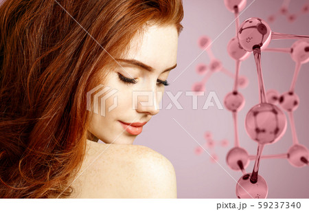 Beautiful redhead woman near big glass molecule structure. Beautiful redhead woman near big glass molecule structure. 59237340