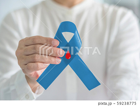 Diabetes Awareness ribbon for World diabetes day with red blood drop on blue bow color in person hand for supporting patient with diabetic disease 59238775