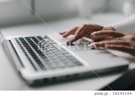 Woman hands are typing on the laptop keyboard, close-up. 59245144