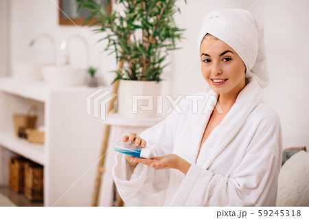 woman uses tonic or lotion product. 59245318