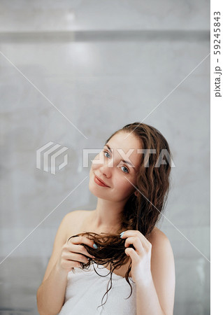 Beautiful young woman touching her wet  hair with 59245843