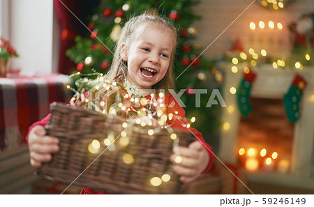 child with garlands near tree at home. 59246149
