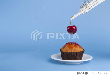 Robot preparing sweet cupcake with cherry, blue background 59247055