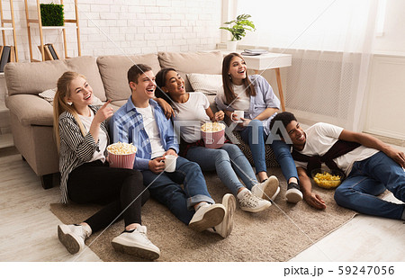 Happy friends watching comedy film and eating popcorn 59247056