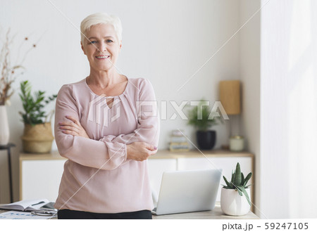 Successful senior woman posing over working place at home 59247105