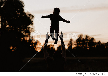 silhouette dad throws his little son in the field in the summer at sunset silhouette dad throws his little son in the field in the summer at sunset 59247815