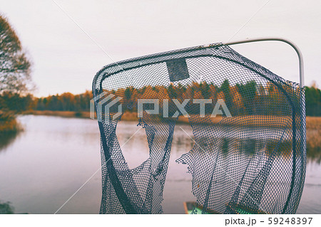 Torn fish net on the lake Torn fish net on the lake 59248397