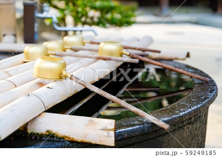 Traditional Japanese ladle for purification in a cleansing well in a peaceful Japanese temple. 59249185