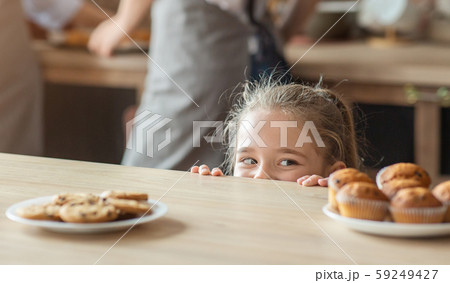 Cute little girl looking with joy at sweets 59249427