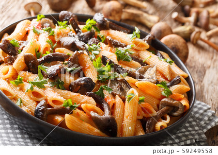 Serving penne pasta with roasted honey mushrooms Serving penne pasta with roasted honey mushrooms 59249558